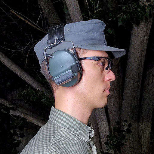 Peltor Comtac III over-the-ear hearing protection and communications headset being worn over a German Bundeswehr field hat.
